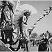 Three Indians in headdress in foreground watching tourists, "Dance, San Ildefonso Pueblo, New Mexico, 1942."